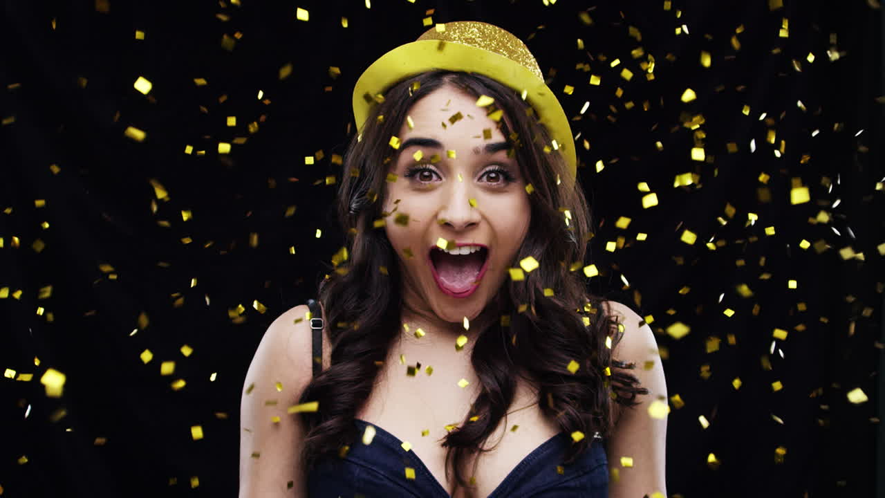 mujer emocionada con sombrero de fiesta y confeti