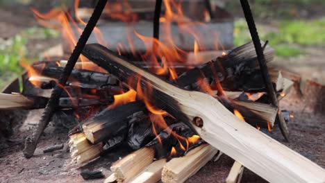 fuego de cocina al aire libre que arde bajo un trípode casero