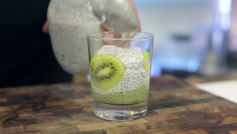 kiwi matcha chia pudding with white coconut chia pudding, healthy food being prepared by chef