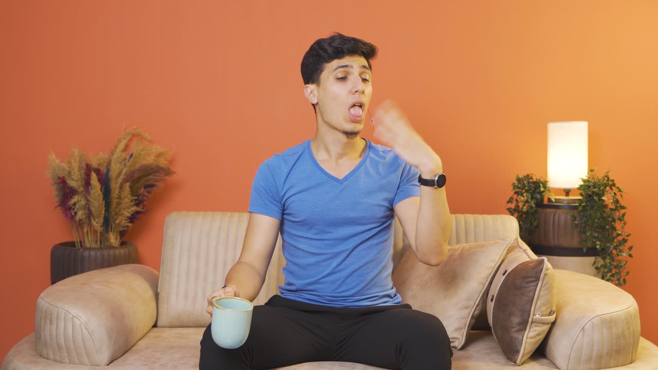 The man's mouth is burning from the hot drink.