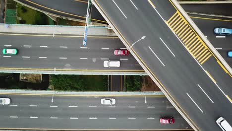 topview drone shot of cars driving the busy highway intersection and freeway bridges of chongqing, huangjuewan, china, during daytime