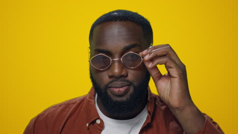 Portrait-of-african-handsome-man-sending-air-kiss-on-yellow-background.