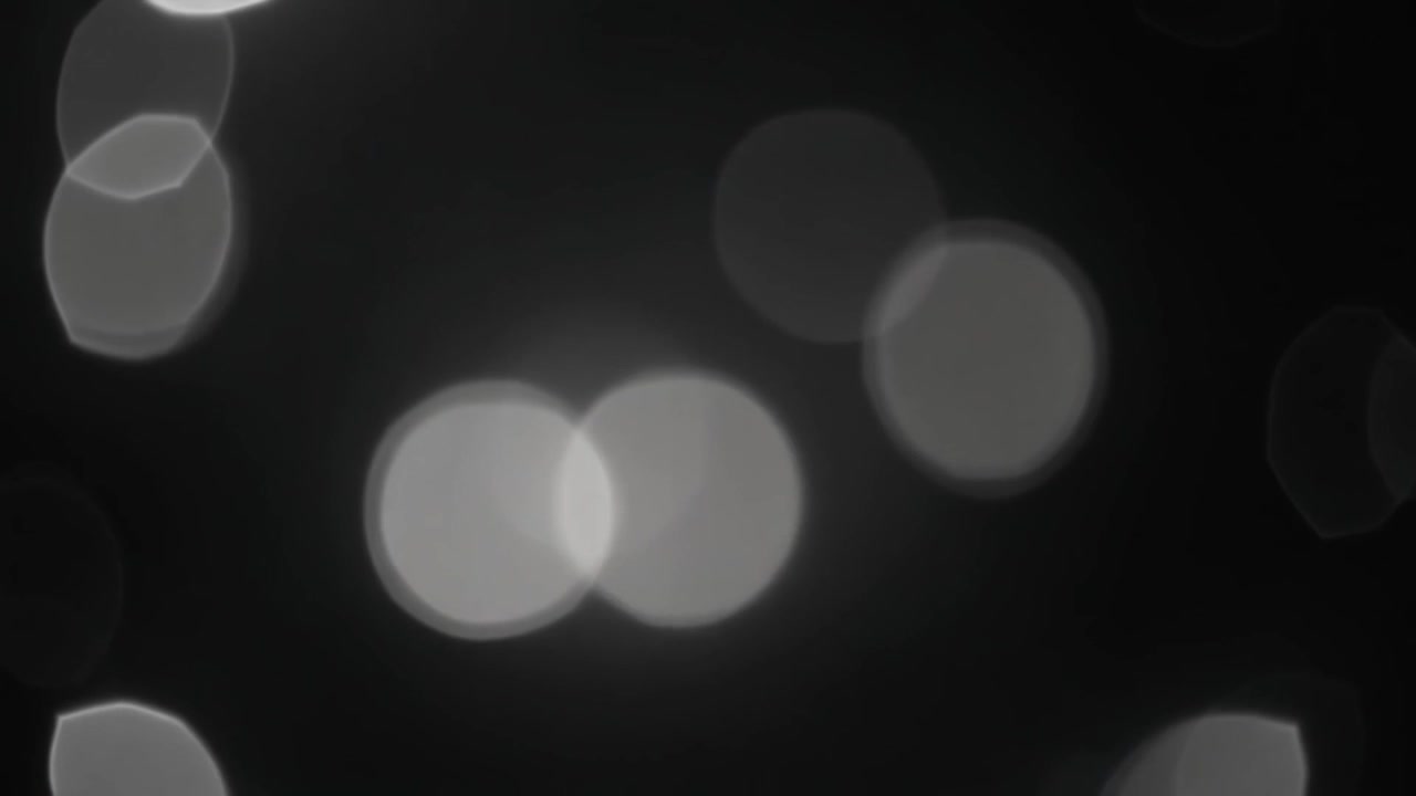 Abstract Background of Soft White Bokeh Lights on Black
