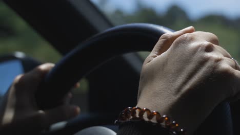 mujer conduciendo un coche en la autopista, primer plano de sus manos y volante