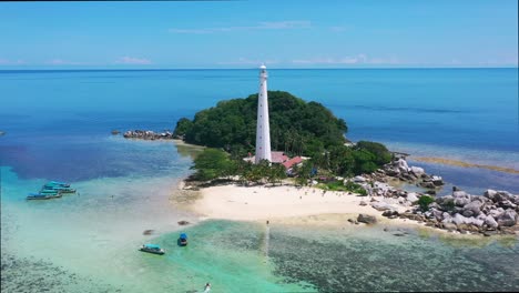 wide aerial panoramic of lengkuas island with a white lightouse surrounded by rocky beach