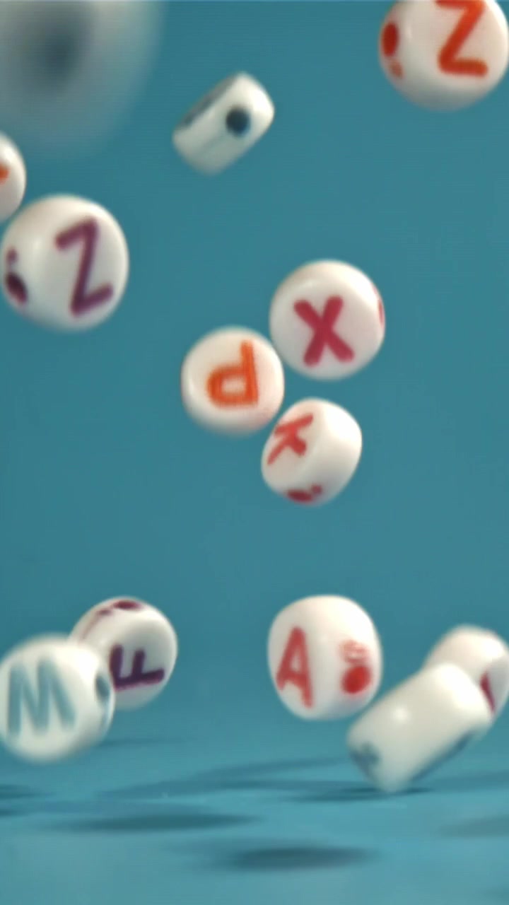 Colorful Alphabet Letter Beads Falling and Bouncing on Blue Background