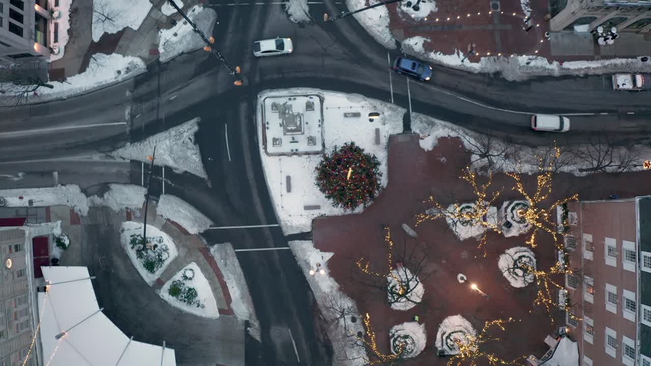 눈과 크리스마스 트리, 조명이 있는 도시 거리를 통과하는 교통의 하향식 공중