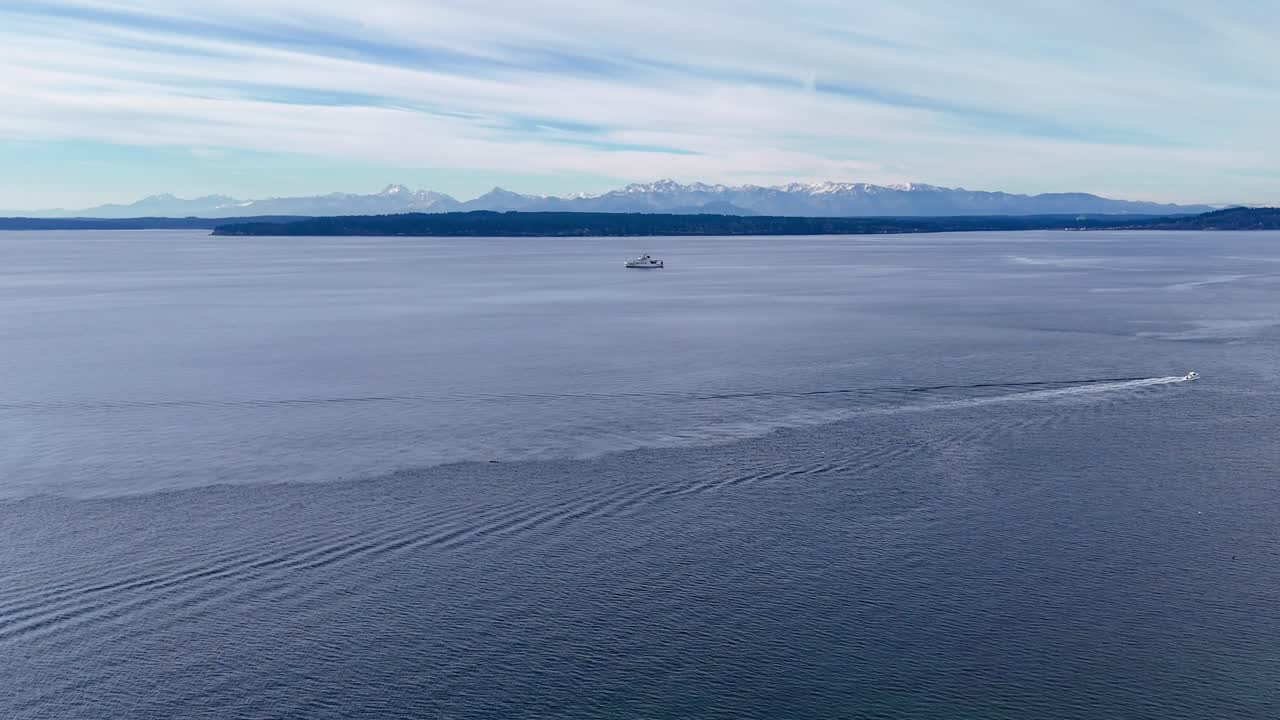 두 배가 풍경적인 푸게트 사운드 (puget sound) 의 물을 항해하는 리치몬드 비치 솔트워터 공원 (richmond beach saltwater park) 근처에서 구름이 가득한 날 배경에 올림픽 산맥이 있습니다.