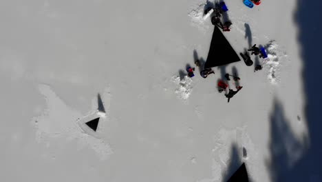 Aerial:-divers-entering-through-an-ice-hole-in-a-frozen-lake