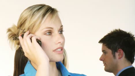 businesswoman on phone with her team in the background