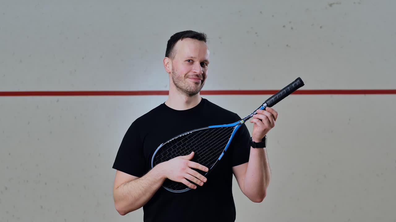 Man strums squash racket like guitar in playful slow motion romantic act