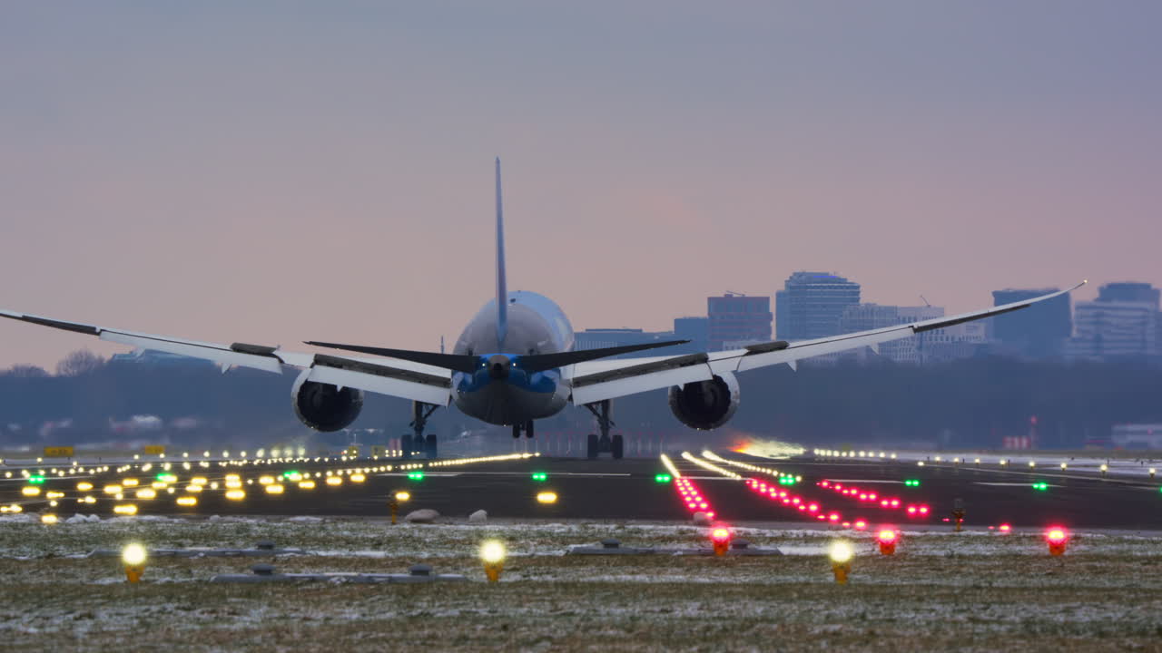 Grande aereo di linea in atterraggio su una pista aeroportuale illuminata al crepuscolo.