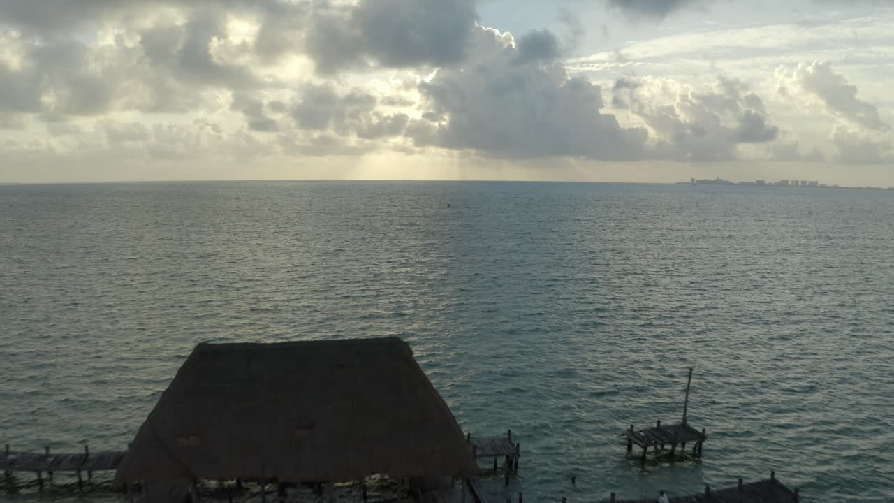 저녁 시간 동안 북미, 멕시코, 칸쿰에 있는 해수에 있는 목재 부두의 공중 무인 항공기 뒤로 이동 샷