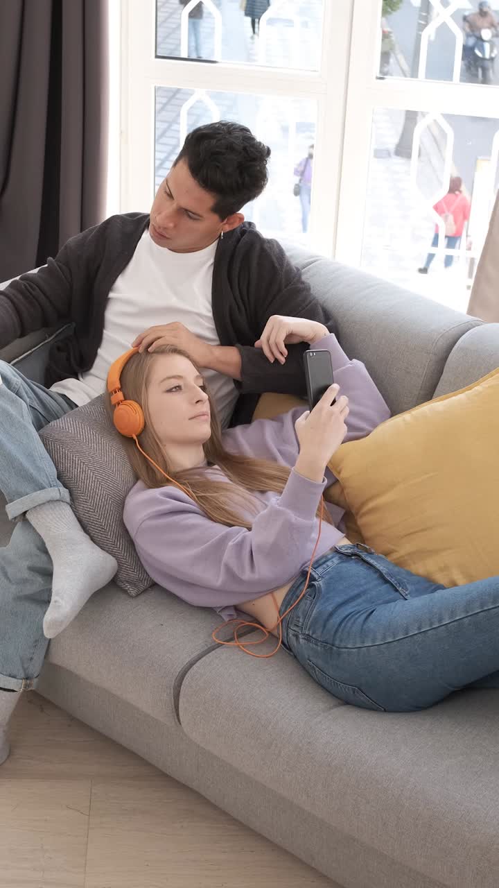 Top view of a young couple relaxing and spending time together on the couch while staying at home.