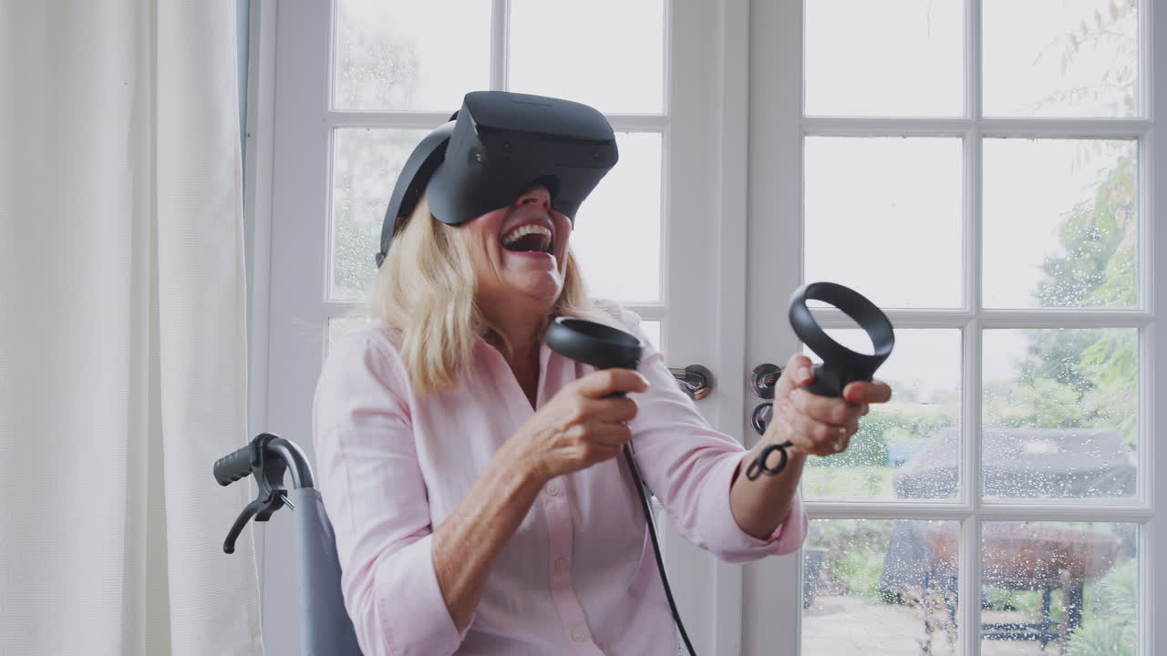 mujer discapacitada madura en silla de ruedas en casa usando auriculares de realidad virtual jugando con controladores