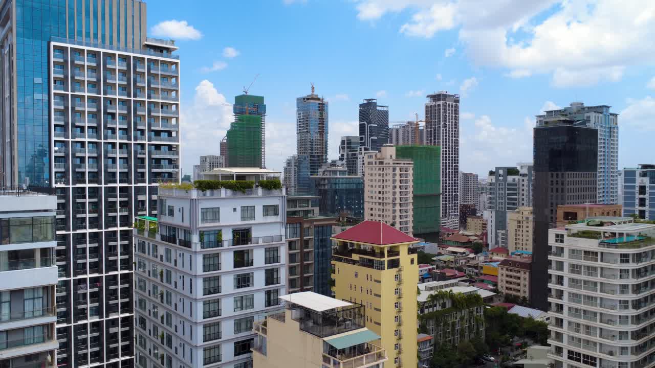 Drone video showcasing modern condos and skyscrapers in BKK1, Phnom Penh. Bright daylight highlights urban architecture. Captures vibrant cityscape and dynamic skyline