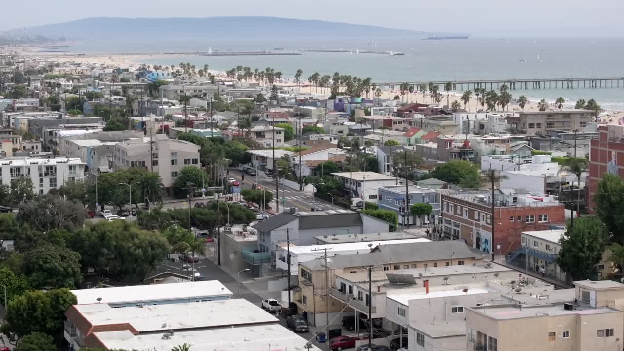 Venice, California aerial flyover over neighborhood toward the famous beach and pier landmark