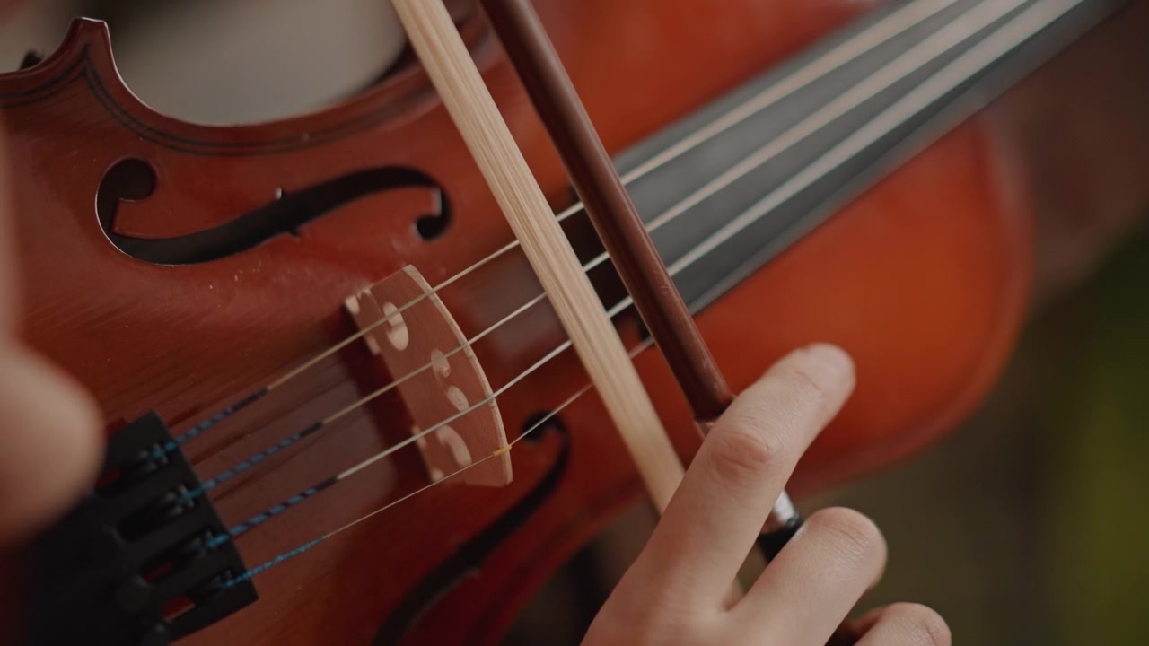 Intimate view of violin string interaction. Macro image emphasizing violin bridge and bow intricacies. Focused photograph showcasing detailed movement and textures of violin strings and bow