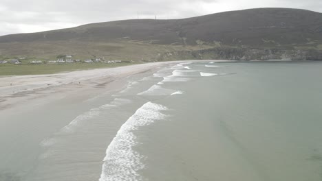 waves and sand dunes on the calm beach of keel at the achill island in county mayo, ireland