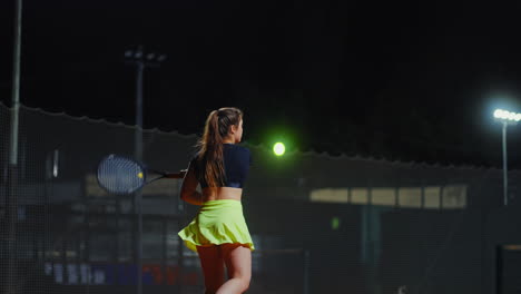 woman playing tennis at night