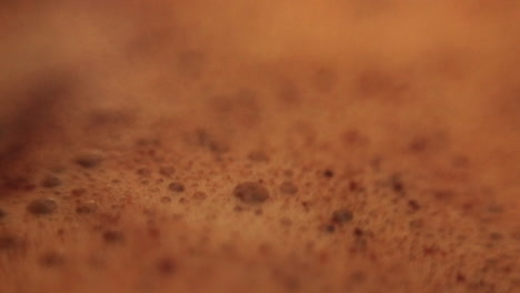 Close-up-stirring-coffee-with-grounds-in-a-mug