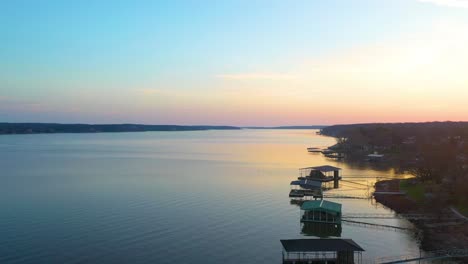 drone takeoff from wooden floating docks for beautiful view or grand lake o' the cherokees in midwest oklahoma during sunrise with glass calm water - aerial ascending