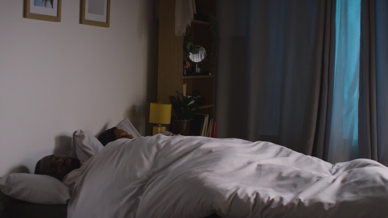 불안한 부부가 밤에 집에서 침대에 누워 있습니다.