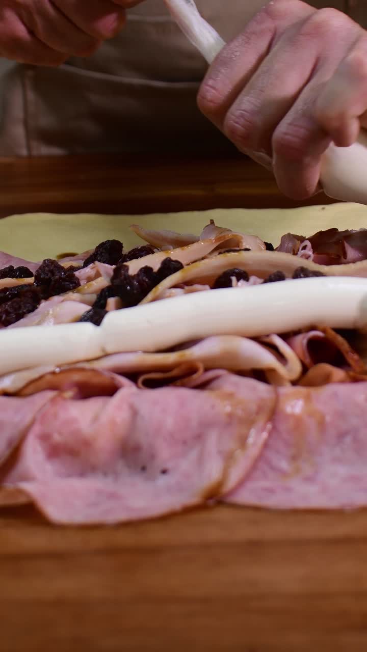 Primo piano di crema di formaggio sull'impasto del pan de jamon, che mostra dettaglio e cura.