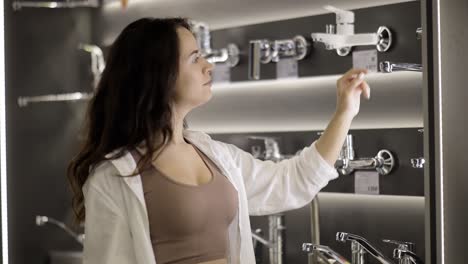 buying a metal faucet for water in a plumbing store.