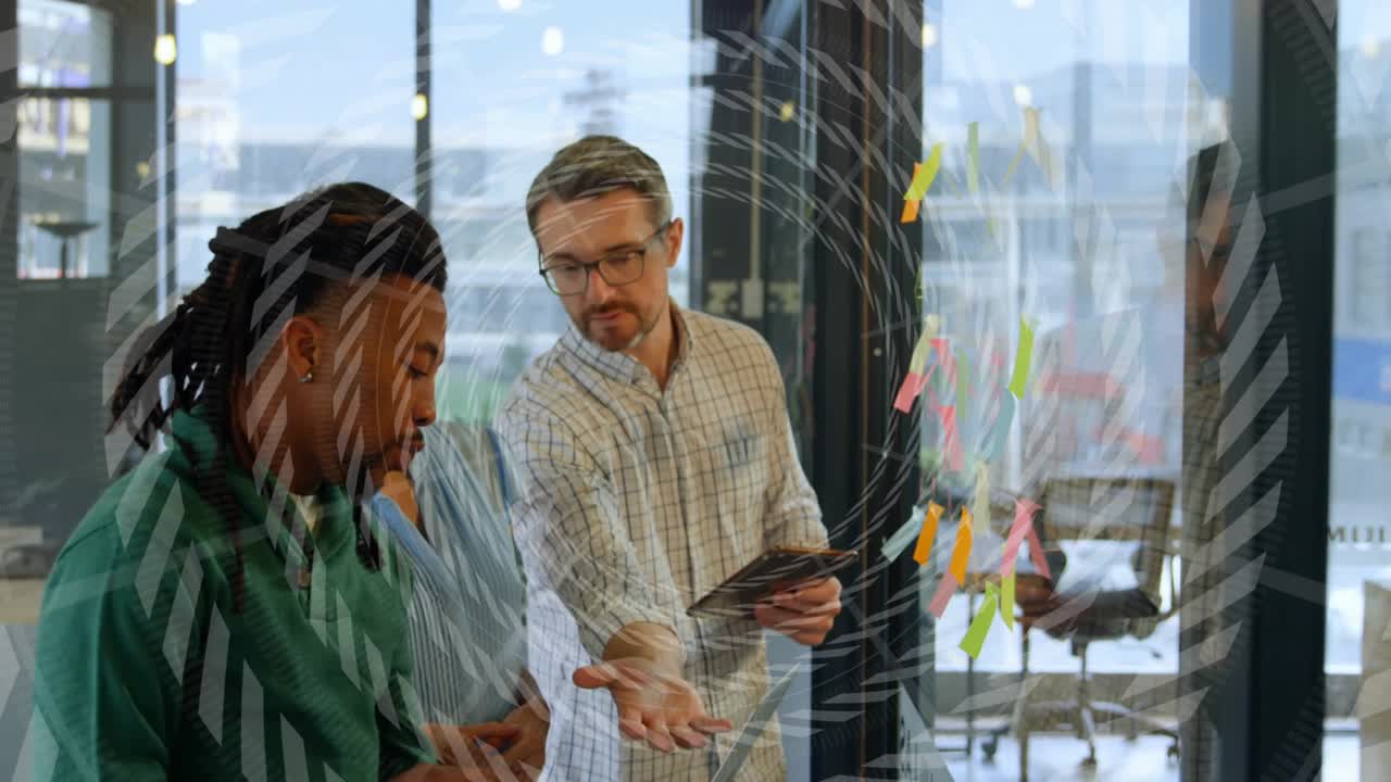Speaker explaining and gesturing, man checking tablet and pointing colored notes for business plan