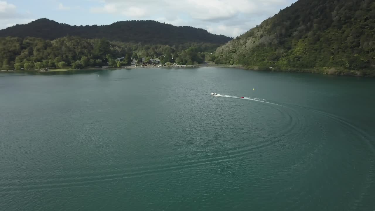 Aerial view of a lake with a boat surrounded by mountains