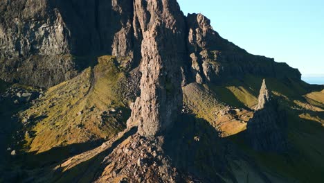 ancient volcanic stone spire the old man of storr and crumbling cliffs with long early morning shadows in winter