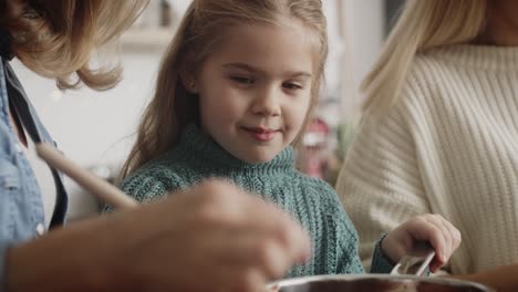 Close-up-video-of-little-girl-cooking-with-mother-and-grandmother