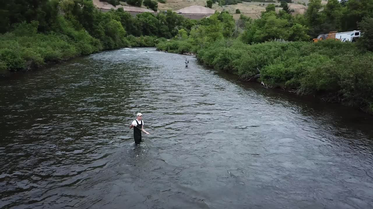 disparo de drone girando alrededor de un hombre pescando con mosca en el río provo en las montañas de utah