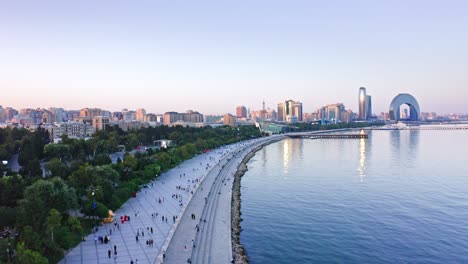 Flying-above-seaside-promenade-in-Baku-city-at-sunset,-Azerbaijan