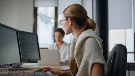 It woman programming code in office. Casual software developer typing computer