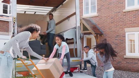 family unloading furniture from removal truck into new home