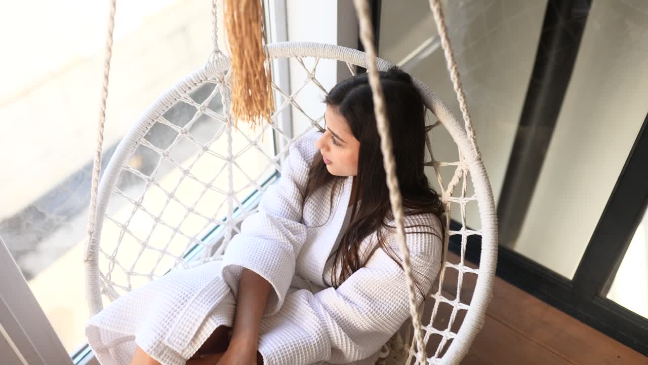 매달린 의자 에서 휴식을 취 하는 여자