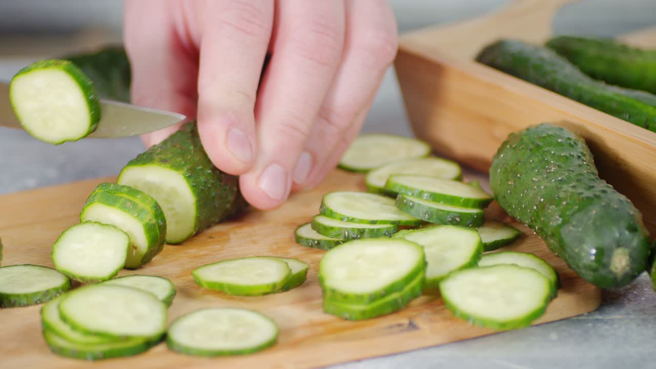 한 남자가 호박을 둥근 조각으로 잘라니다.