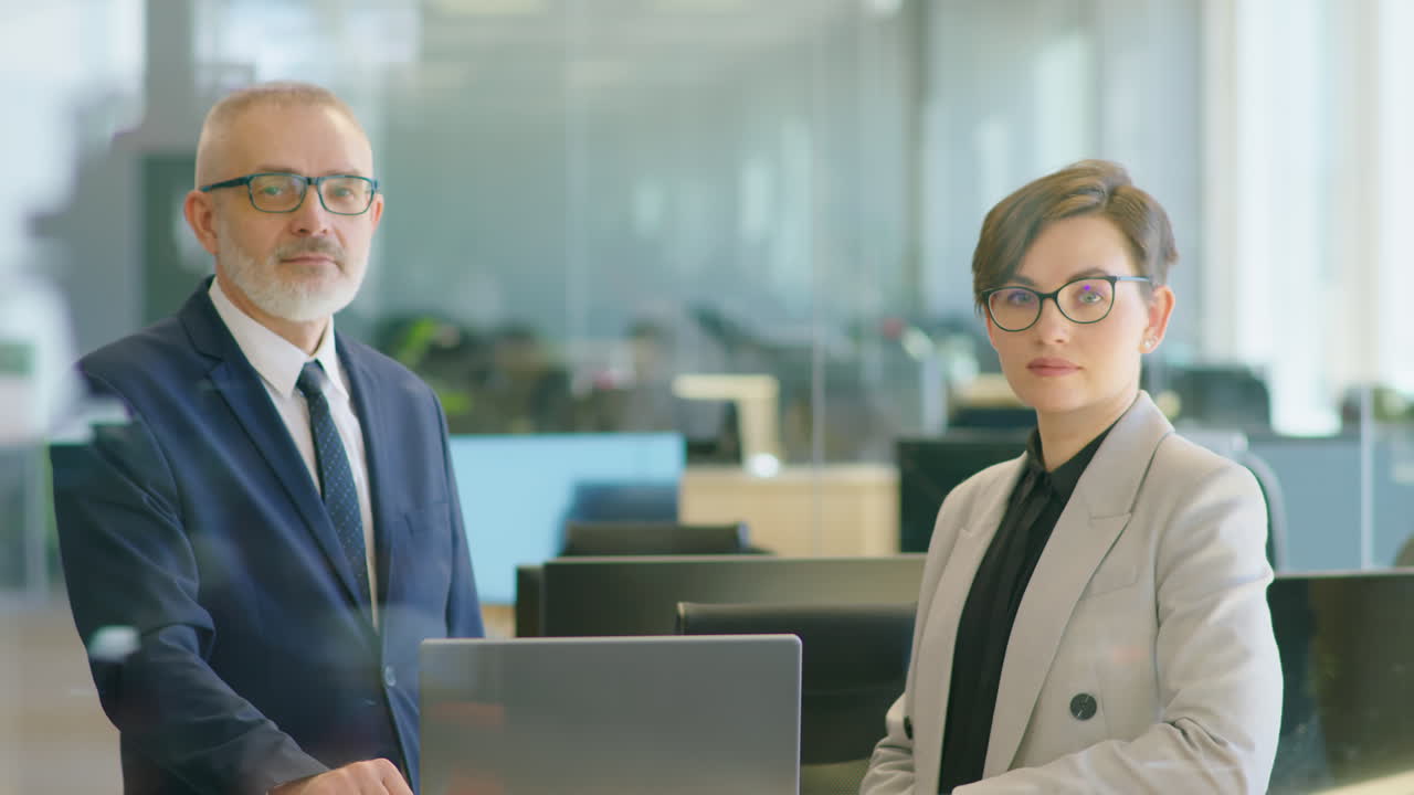 Portrait of Senior Businessman and Young Woman in Office