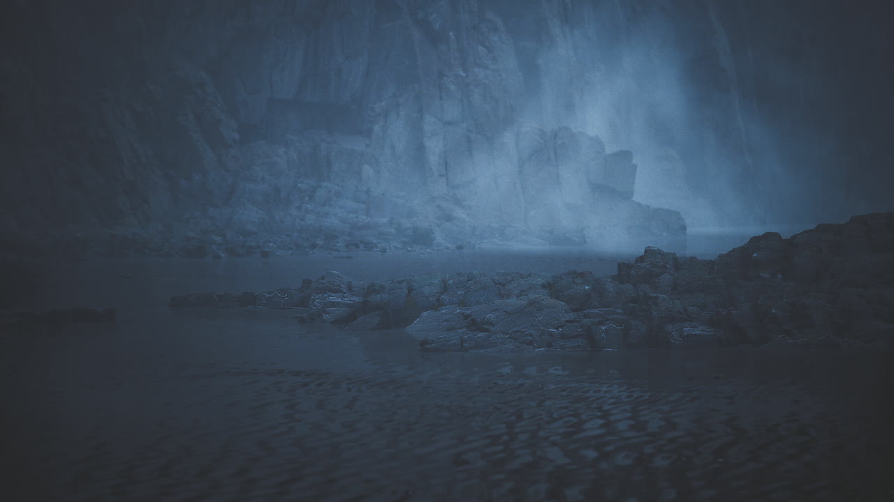 Mysterious blue landscape with fog covering the rocky terrain at dusk