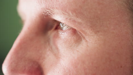 a close-up view of a technician's face with closed eyes, emphasizing concentration and relaxation with a green blur background