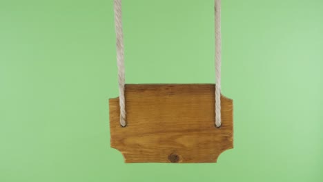 el puntero de madera se balancea en el viento, aislado en una pantalla verde.