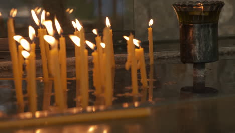 candles burning on tabletop in greek orthodox church