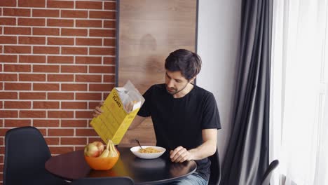 Handsome-man-pouring-corn-flakes-into-bowl