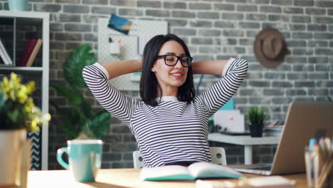 woman relaxing while working on laptop at home