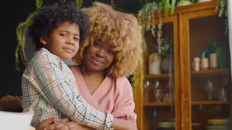 portrait of happy african american mother and kid at home