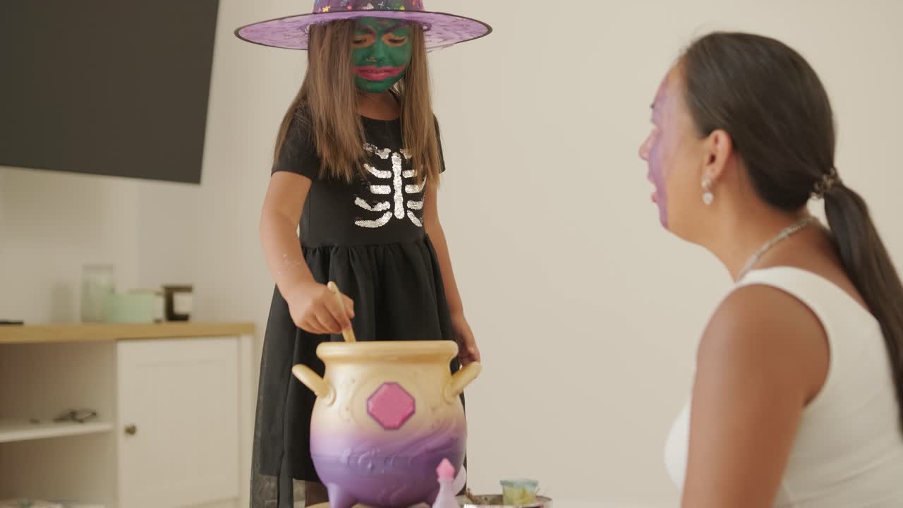 Pregnant Mother Watching Daughter Play on Slide at Playground