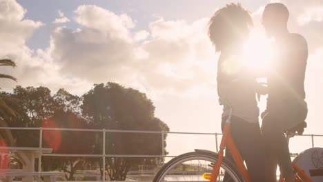 couple interacting with each other in cycle at beach 4k