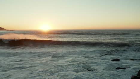 Olas-Del-Océano-Atlántico-Rompiendo-En-La-Orilla-De-La-Playa-Al-Atardecer-En-Ciudad-Del-Cabo,-Sudáfrica